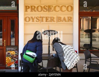 Krakau. Krakau. Polen. Zwei junge Frauen lesen das Menü vor der Prosecco Oyster Bar. Stockfoto