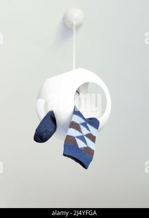 Eine Raute mit Karomuster hängt an einem Deckenleuchter. National Lost Sock Memorial Day Konzept. Stockfoto