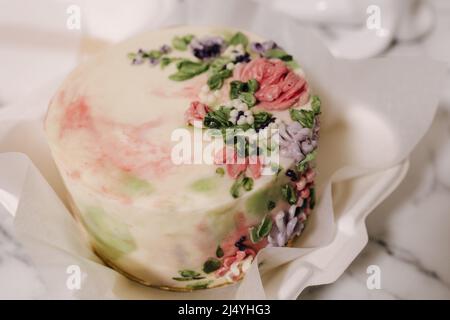 Kleine Bento-Torte, verziert mit Zuckerblumen als Geschenk für den Urlaub. Kuchen in einer Schachtel für eine Person Stockfoto