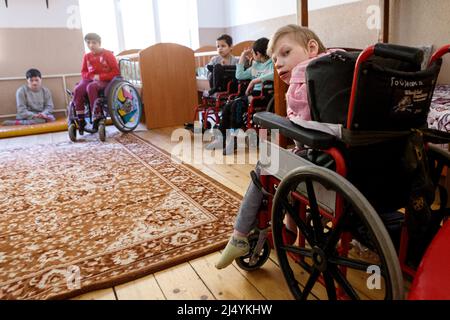 VILSHANY, UKRAINE - 15. APRIL 2022 - Kinder mit besonderen Bedürfnissen, die aus Einrichtungen in der Region Zhytomyr und Kryvyi Rih evakuiert wurden, bleiben am Wildschwein Stockfoto