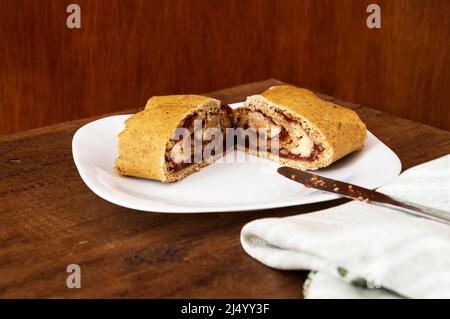 Zwei Scheiben Brot, gefüllt mit Guava und Frischkäse auf einem quadratischen Teller Stockfoto