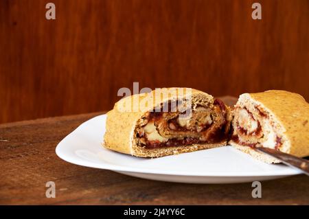 Zwei Scheiben Brot, gefüllt mit Guava und Frischkäse auf einem quadratischen Teller Stockfoto