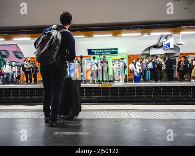 Ein Reisender, der an der U-Bahn-Haltestelle auf die Ankunft des Zuges wartet. Stockfoto