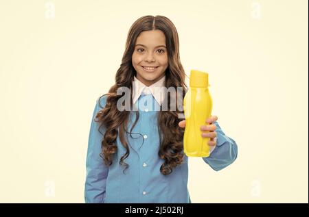 Glückliches Kind geben gelbe Plastikflasche mit Getränkeprodukt isoliert auf weißen, trinkbaren Stockfoto