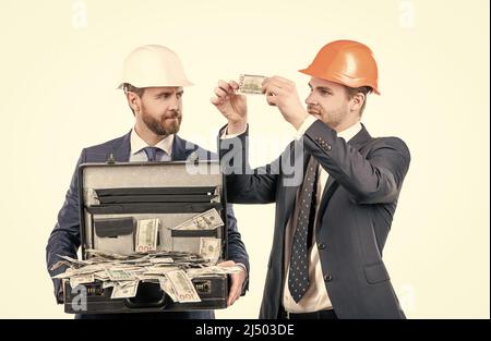 Finanzielle Unterstützung. Investition in Architekturprojekt. Zwei Männer Geschäftsmann in Hardhat mit Geld. Stockfoto