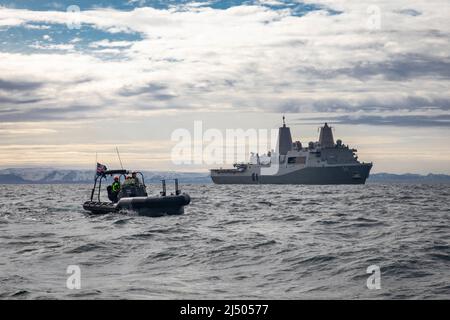 220412-N-PC065-1339 ATLANTISCHER OZEAN – ein aufblasbares Boot der isländischen Küstenwache mit starrem Rumpf manövriert in der Nähe des Amphibientransportschiffes USS Arlington (LPD 24) der San Antonio-Klasse vor der Küste Islands während der Übung Northern Viking 2022, 12. April 2022. Arlington befindet sich unter dem Kommando und der Kontrolle der Task Force 61/2 im planmäßigen Einsatz, während er in der US-Flotte von 6. zur Unterstützung der Interessen der USA, der Alliierten und der Partner in Europa und Afrika tätig ist. Northern Viking 22 stärkt die Interoperabilität und die Einsatzbereitschaft zwischen den USA, Island und den alliierten Nationen und ermöglicht so Multi-Domain-Befehle und Stockfoto