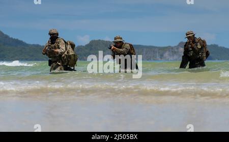 Ein Mitglied der Philippine Navy Special Operations Group, U.S. Navy SEAL und ein australischer Operator mit 2. Commando Regiment, Special Operations Command, führen während der Balikatan 22 in El Nido, Palawan, Philippinen, einen amphibischen Angriff durch, 1. April 2022. Balikatan ist eine jährliche Übung zwischen den Streitkräften der Philippinen und dem US-Militär, die darauf ausgerichtet ist, bilaterale Interoperabilität, Fähigkeiten, Vertrauen und Zusammenarbeit zu stärken, die über Jahrzehnte gemeinsamer Erfahrungen aufgebaut wurde. Balikatan, Tagalog für ‘„Schulter an Schulter“, ist eine seit langem bestehende bilaterale Übung zwischen den Philippinen und der Vereinigten Staaten Stockfoto