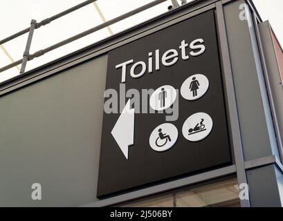 Schwarz-weißes Toilettenschild mit Symbolen für Männer, Damen, Behinderte und Baby-Wechsel. Stockfoto