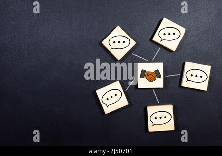 Konzept der Online-Kommunikation oder Social Networking. Holzwürfel mit Sprechblasen, die mit Linien miteinander verbunden sind. Stockfoto