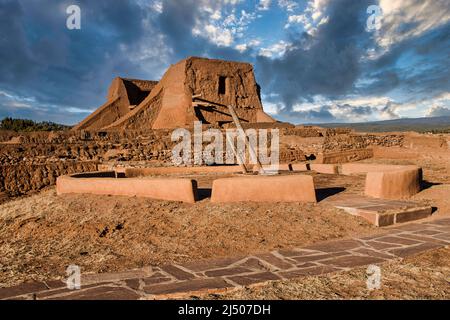 Eine Native American Kiva Rekonstruktion durch die Ruinen der Spanischen Missionskirche im Pecos National Historical Park in New Mexico. Stockfoto