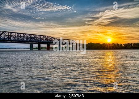 Die Sonne untergeht über der Küste von Arkansas an der Harahan Bridge am Mississippi River bei Memphis, Tennessee. Stockfoto