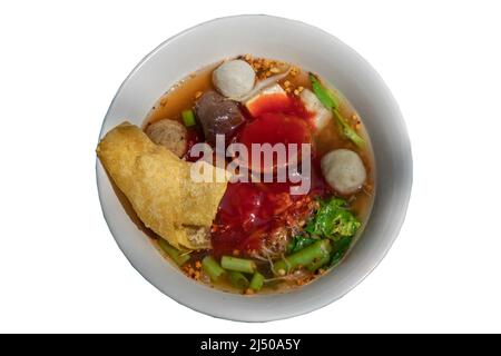 Traditionelle Yentafo- oder Eiernudeln-Suppe mit rosa Sauce und Fischbällchen, Garnelenkugel, Schweineblut, chinesischem Morgenruhm und gebratenem Wonton in weißer Schüssel Stockfoto