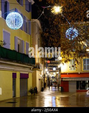 Zentrale Straße der französischen Stadt Monzelimar mit Weihnachtsschmuck in der Dämmerung Stockfoto