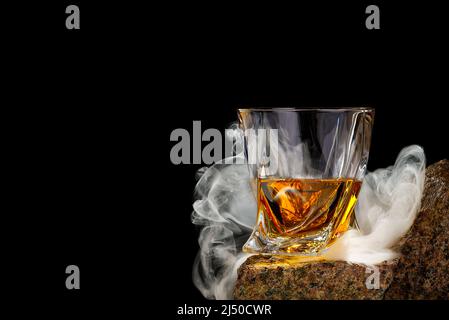 Wisky Glas auf dem Felsen auf schwarzem Hintergrund. Wisky Glas ohne Eis Stockfoto