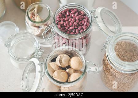 Gläser, Lebensmittel, Nüsse, Bohnen und Buchweizen. Zero Waste Kitchen. Kunststoff-Freie Pantry. Kein Kunststoff. Öko-Familienleben, Nahaufnahme Stockfoto