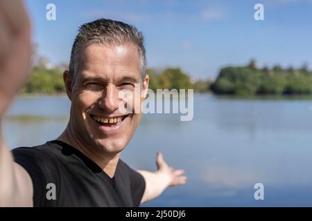 Aktiver, hübscher, reifer Kaukasischer Mann, der Selfie auf einem See zeigt. Outdoor-Adventure-Konzept. Stockfoto