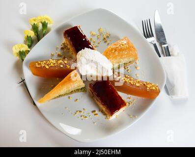 Gemischter Dessertteller in türkischer Küche. Scheiben Baklava, Trilece und Kürbis Dessert sind auf einem Teller. Stockfoto