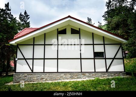 Seitenfassade einstöckiges privates Wohnhaus mit Fachwerkdekor und Steinsockel. Stockfoto