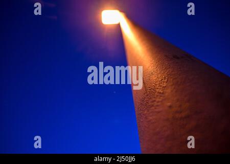 Ravensburg, Deutschland. 19. April 2022. Am frühen Morgen leuchtet eine Straßenlaterne zur Blauen Stunde. Quelle: Felix Kästle/dpa/Alamy Live News Stockfoto