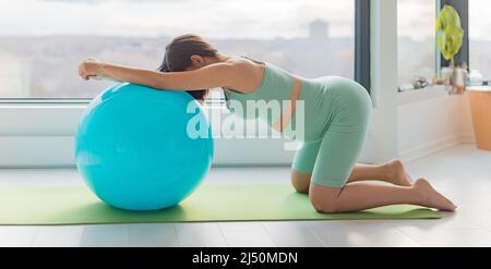 Schwanger Frau Training Wehen Position Stretch Knien auf Geburtsball auf ihre Hände und Knie Dehnung Hause Schwangerschaft Workout Banner Stockfoto