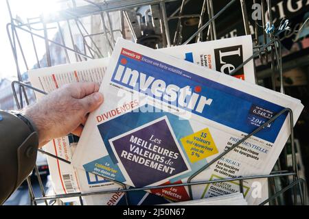 Paris, Frankreich – 11 2022. Apr: Man Buy schaut beim Zeitungskioské bei Zeitungsinvestitionstir nach den besten ROI-Optionen auf dem Markt Stockfoto