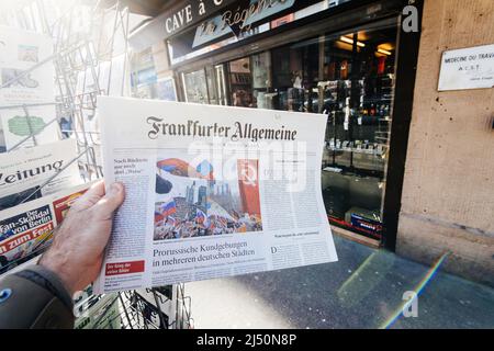 Paris, Frankreich - 11. Apr 2022: Frankfurter Allgemeine Zeitung mit Schlagzeile zum Ukraine-Krieg - Protest prorussischer Truppen in Deutschland - Mann, der nach der neuesten Presse kauft Stockfoto