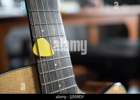 Gelbe Gitarre Pick auf einer akustischen Gitarre Stockfoto