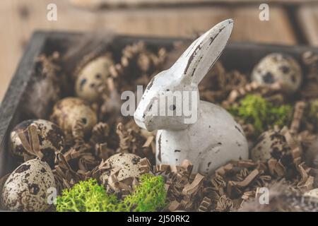 Holzdekoration Osterhase mit kleinen Wachteleiern und Dekoration in natürlichen Farben, christliche Tradition Stockfoto