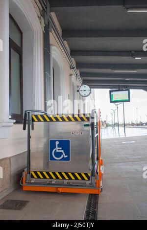 Sonderlift für Rollstühle am Bahnhof. Assistenzdienst für Bahnbehinderte Stockfoto