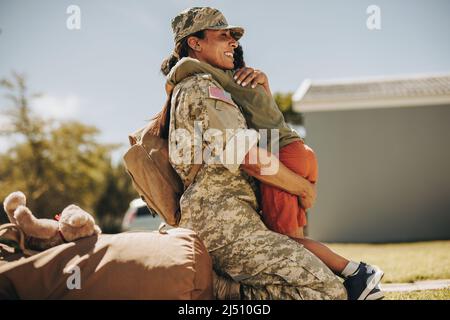 Freudige Militärmutter umarmt ihren Sohn, nachdem sie von der Armee nach Hause zurückgekehrt ist. Mutige Soldatinnen, die sich nach dem Dienst im Th Stockfoto