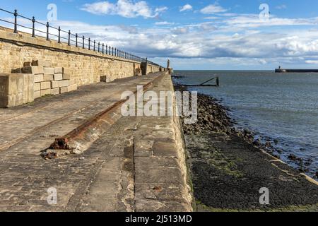 Tynemouth North Pier und Leuchtturm an der Mündung des Flusses Tyne, mit South Shields Pier in der Ferne. Aufgenommen an einem sonnigen Frühlingstag. Stockfoto