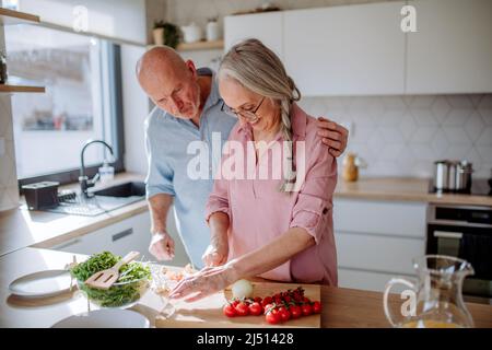 Glückliches Seniorenpaar, das zu Hause zusammen kocht. Stockfoto