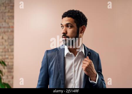 Seriöse junge Geschäftsmann schaut weg, Studio geschossen. Stockfoto