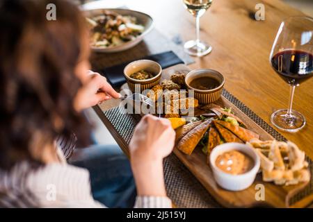 Nahaufnahme einer erwachsenen Frau, die im Restaurant zu Abend gegessen und Wein getrunken hat. Stockfoto