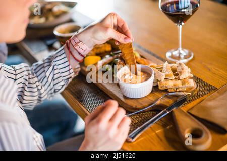 Nahaufnahme einer erwachsenen Frau, die im Restaurant zu Abend gegessen und Wein getrunken hat. Stockfoto
