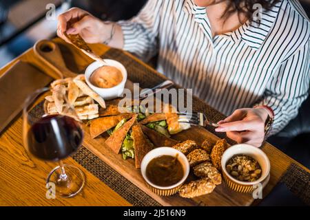 Nahaufnahme einer erwachsenen Frau, die im Restaurant zu Abend gegessen und Wein getrunken hat. Stockfoto