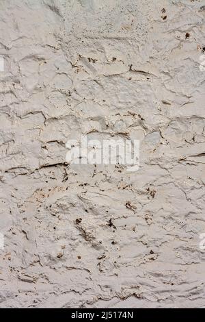 Struktur der verputzten alten Wand mit Rissen. Stockfoto