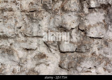Glatte Wand von alten Blöcken verschiedener Größen auf Zementmörtel. Stockfoto