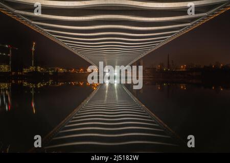 Unter der Troja-Brücke in Prag mit bemerkenswerten Brückenrippen, die von Lichtern beleuchtet sind. Am besten kann man nachts den unglaublichen Brückenbau genießen. Stockfoto
