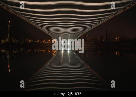 Unter der Troja-Brücke in Prag mit bemerkenswerten Brückenrippen, die von Lichtern beleuchtet sind. Am besten kann man nachts den unglaublichen Brückenbau genießen. Stockfoto