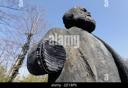 Neubrandenburg, Deutschland. 19. April 2022. Das Denkmal des Philosophen Karl Marx steht ohne seinen rechten Unterarm an seinem Platz in einem Park. Unbekannte hatten die 2,20-Meter-Statue im Februar 2022 beschädigt und den Arm abgenommen. Die Statue, eine Auftragsarbeit des Berliner Bildhauers Thieme aus dem Jahr 1969, soll wieder fertiggestellt werden. Die Stadt will Spenden erbitten, damit das Denkmal noch vor Ende 2022 fertiggestellt werden kann. Quelle: Bernd Wüstneck/dpa/Alamy Live News Stockfoto