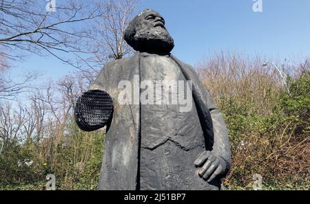 Neubrandenburg, Deutschland. 19. April 2022. Das Denkmal des Philosophen Karl Marx steht ohne seinen rechten Unterarm an seinem Platz in einem Park. Unbekannte hatten die 2,20-Meter-Statue im Februar 2022 beschädigt und den Arm abgenommen. Die Statue, eine Auftragsarbeit des Berliner Bildhauers Thieme aus dem Jahr 1969, soll wieder fertiggestellt werden. Die Stadt will Spenden erbitten, damit das Denkmal noch vor Ende 2022 fertiggestellt werden kann. Quelle: Bernd Wüstneck/dpa/Alamy Live News Stockfoto