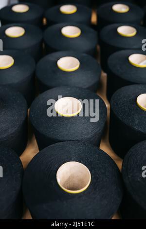Baumwollgarne oder -Fäden auf Spulenspulen in der Baumwollgarnfabrik. Stockfoto