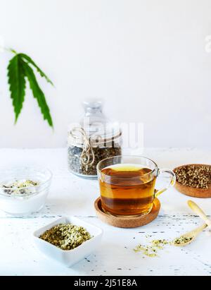 Hanfprodukte: Kräutertee, geschälte und ganze Samen, Joghurt mit Samen, Cannabisblatt Stockfoto