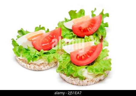 Reiskuchen-Sandwiches mit Tomaten, Salat und Ei - isoliert auf Weiß. Einfaches Frühstück. Diät-Essen. Schnelle und gesunde Sandwiches. Knäckebrot mit leckerer Füllung. Gesunde Ernährung Snack - Isolation Stockfoto
