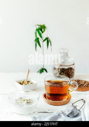 Hanf-Produkte: Kräutertee trocken und frisch in Tasse, Samen geschält und ganz, Joghurt mit Samen, Cannabispflanze Stockfoto