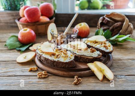 Brotscheiben mit Quark, Honig, Äpfeln und Nüssen Stockfoto