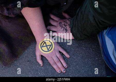 London, Großbritannien. 16. April 2022. Extinction Rebellion (XR)-Aktivisten sprangen auf eine Schwarze Limousine und saßen auf dem Boden und klebten sich in Marble Arch. Später wurde ein Transparent mit der Aufschrift ‘'Stop fossile Brennstoffe now' auf den Bogen gesetzt. Der heutige Tag war Teil einer einwöchigen Welle von Protesten und zivilen Ungehorsamsmaßnahmen, die die britische Regierung angesichts der Klimakrise und der ökologischen Notlage dazu aufforderte, die gesamte neue Infrastruktur für fossile Brennstoffe sofort zu stoppen. Stockfoto