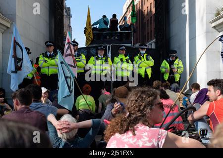 London, Großbritannien. 16. April 2022. Extinction Rebellion (XR)-Aktivisten sprangen auf eine Schwarze Limousine und saßen auf dem Boden und klebten sich in Marble Arch. Später wurde ein Transparent mit der Aufschrift ‘'Stop fossile Brennstoffe now' auf den Bogen gesetzt. Der heutige Tag war Teil einer einwöchigen Welle von Protesten und zivilen Ungehorsamsmaßnahmen, die die britische Regierung angesichts der Klimakrise und der ökologischen Notlage dazu aufforderte, die gesamte neue Infrastruktur für fossile Brennstoffe sofort zu stoppen. Stockfoto