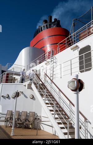 Blick vom Promenadendeck auf Cunards Luxuskreuzfahrtschiff, die RMS Queen Elizabeth, zeigt den riesigen roten Trichter Stockfoto